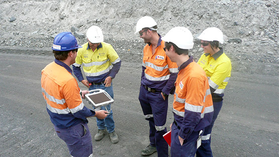 Jordan Herrmann demonstrating the Maptek laser scanner to the Downer crew at Meandu in 2014.