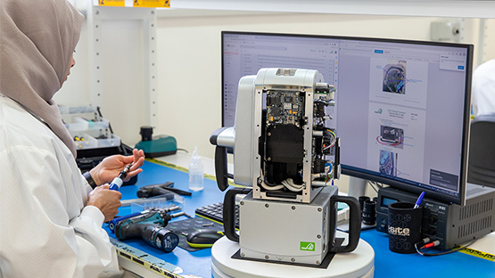 Una empleada de fabricación de Maptek ensamblando un escáner.